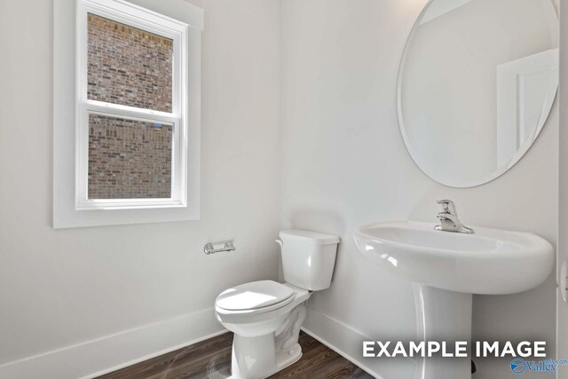 bathroom with wood finished floors, toilet, and baseboards