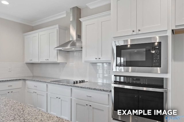 kitchen featuring black electric stovetop, white cabinets, stainless steel oven, built in microwave, and wall chimney exhaust hood