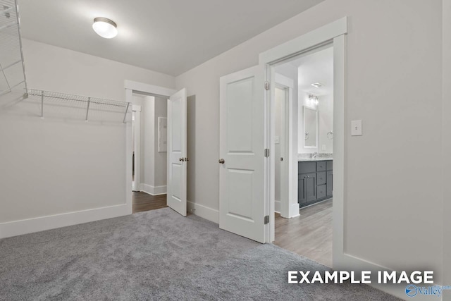 unfurnished bedroom with carpet, baseboards, and a sink