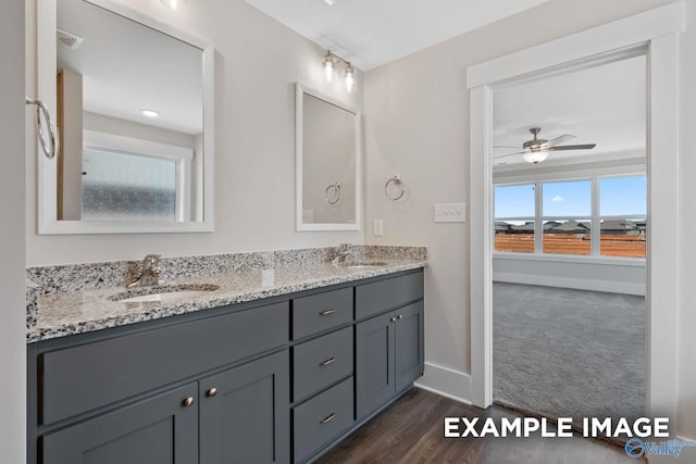 full bath featuring ceiling fan, a sink, baseboards, and double vanity