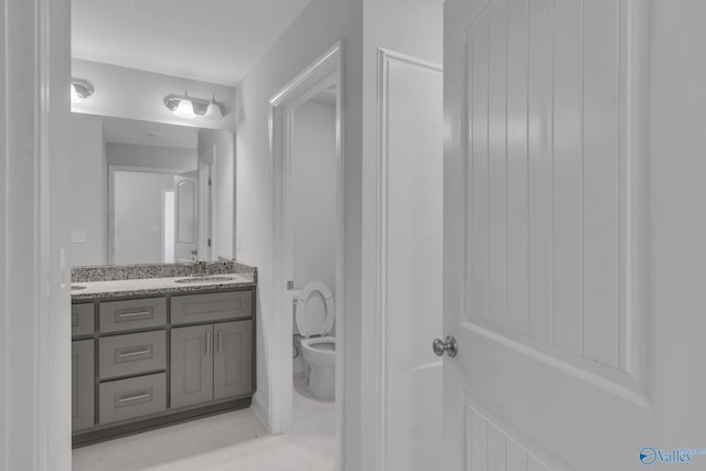 bathroom featuring a sink, toilet, and double vanity