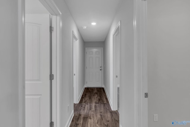 hall with dark wood-type flooring and baseboards