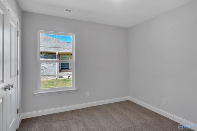 spare room with visible vents, baseboards, and carpet