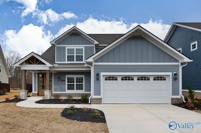 craftsman house featuring a garage, brick siding, board and batten siding, and driveway