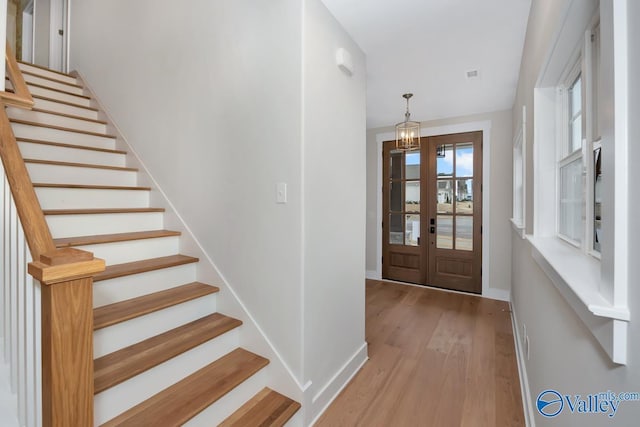 entryway featuring stairway, baseboards, and wood finished floors