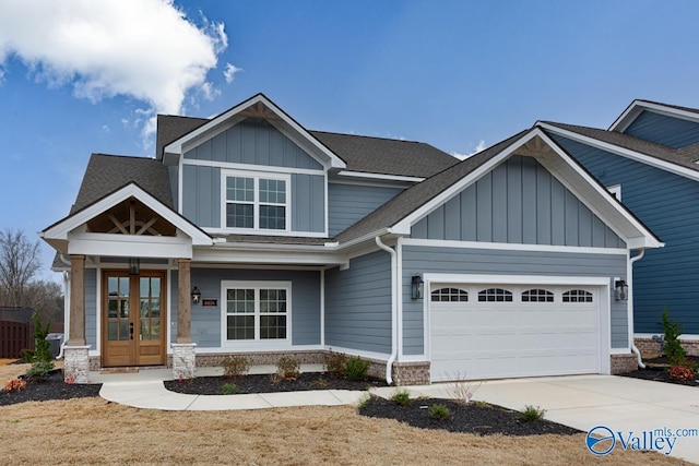 craftsman-style home featuring concrete driveway, an attached garage, french doors, and board and batten siding