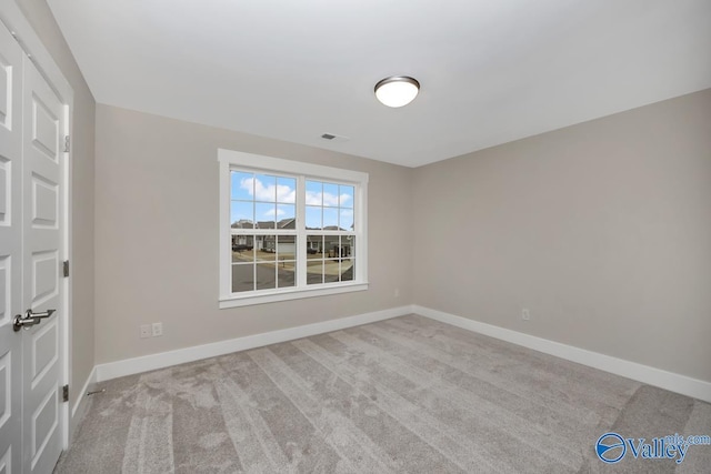 empty room featuring baseboards and carpet floors