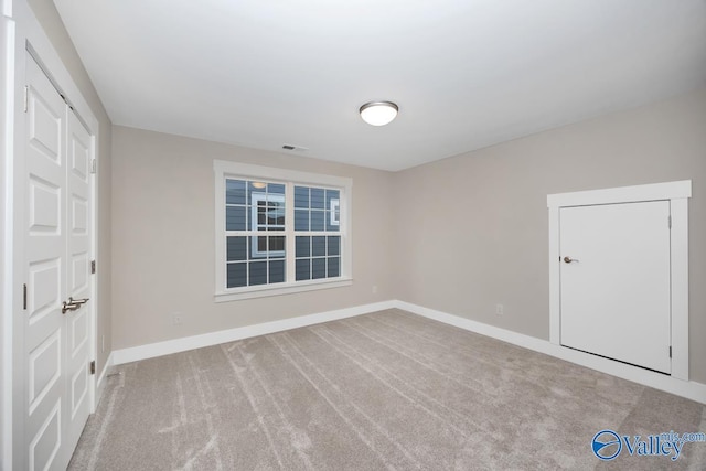 spare room featuring visible vents, baseboards, and carpet floors