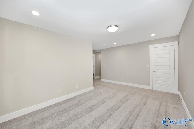 empty room featuring recessed lighting, baseboards, and light carpet