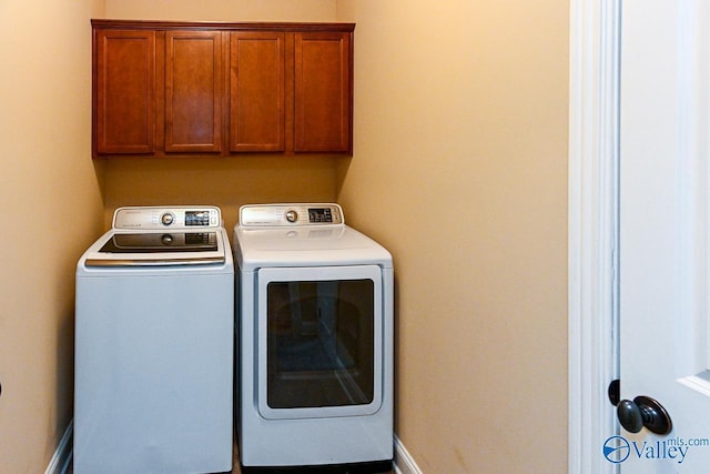 washroom with cabinets and washing machine and clothes dryer