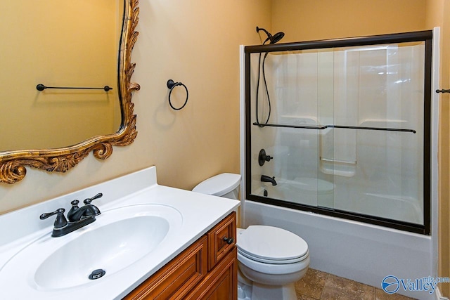 full bathroom featuring vanity, shower / bath combination with glass door, and toilet