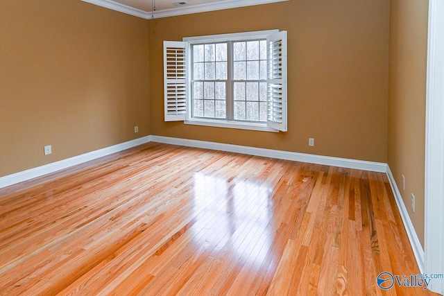 spare room featuring ornamental molding and light wood-type flooring