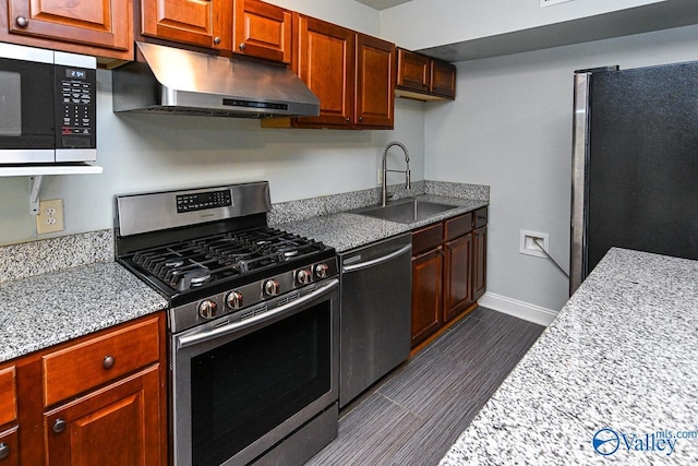 kitchen with dark hardwood / wood-style floors, appliances with stainless steel finishes, sink, and light stone counters