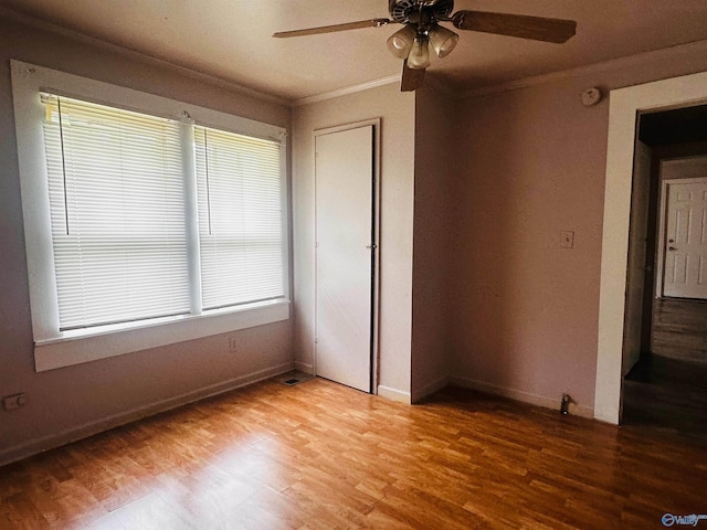 interior space with wood-type flooring, crown molding, and ceiling fan