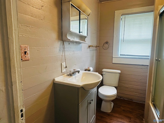 bathroom with wood walls, vanity, toilet, and hardwood / wood-style floors