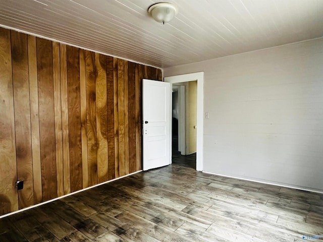 unfurnished room featuring hardwood / wood-style flooring and wooden walls