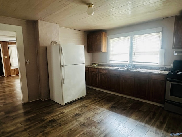 kitchen featuring dark hardwood / wood-style floors, white fridge, sink, and stainless steel range with electric cooktop