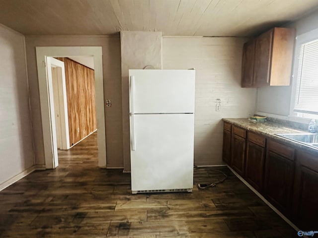 kitchen with sink, white fridge, and dark wood-type flooring