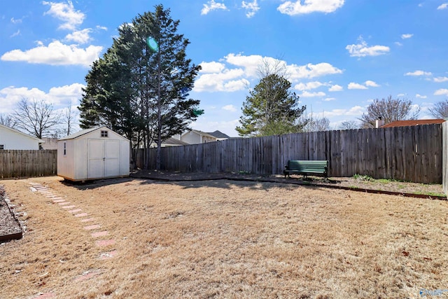 view of yard with a storage shed, a fenced backyard, and an outdoor structure