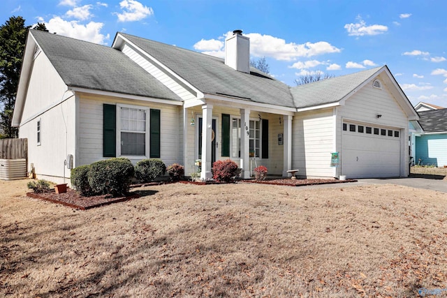 single story home with driveway, a chimney, and an attached garage