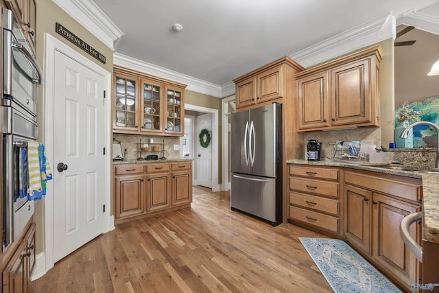 23245 Piney Creek Dr, Athens, AL 35613 - kitchen featuring freestanding refrigerator, a sink, tasteful backsplash, brown cabinets, and light stone countertops
