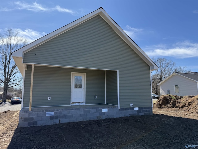 rear view of property featuring covered porch and crawl space