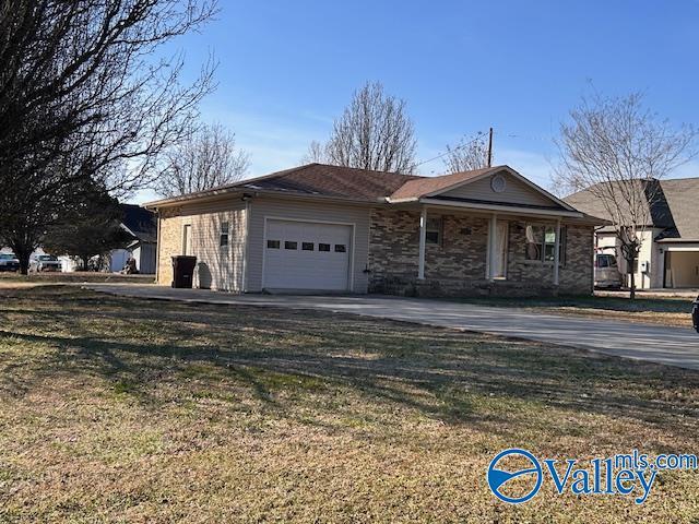 ranch-style house featuring a garage and a front lawn