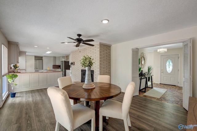 dining room with ceiling fan, dark hardwood / wood-style floors, and a textured ceiling