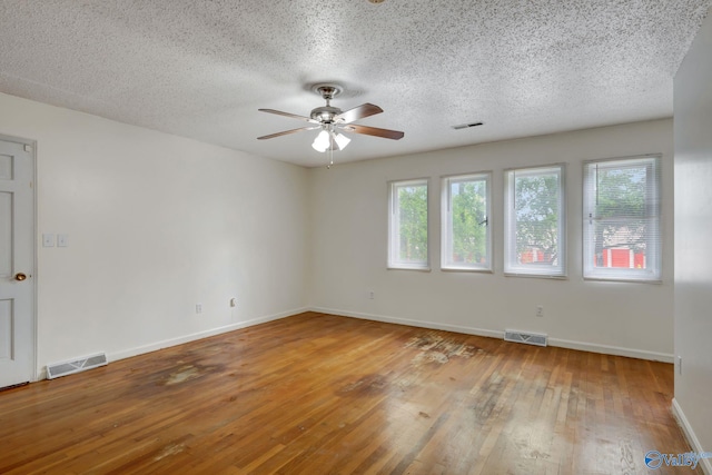 spare room featuring a textured ceiling, hardwood / wood-style flooring, and ceiling fan