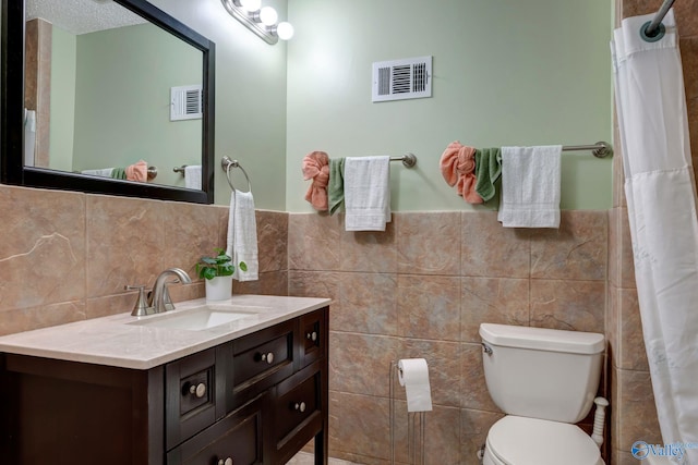 bathroom featuring vanity, decorative backsplash, tile walls, and toilet