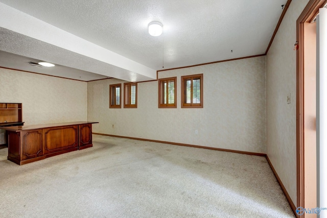 basement with ornamental molding, light carpet, and a textured ceiling