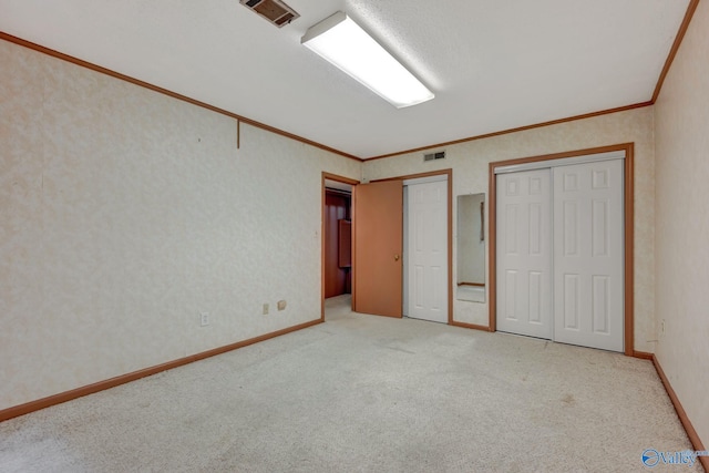 unfurnished bedroom featuring multiple closets, ornamental molding, and carpet flooring