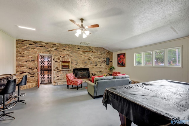 rec room with ceiling fan, a textured ceiling, brick wall, pool table, and lofted ceiling