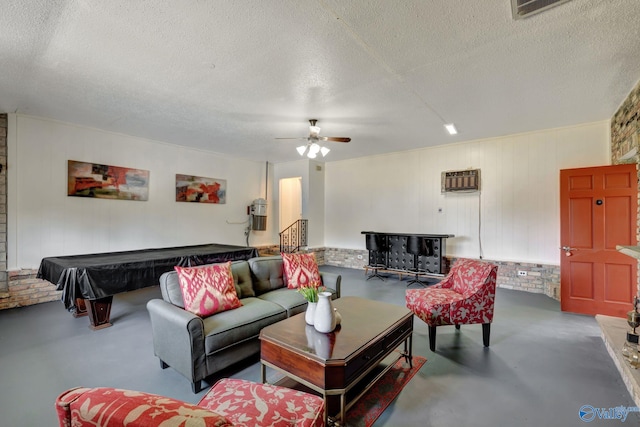 living room featuring concrete flooring, ceiling fan, billiards, and a textured ceiling