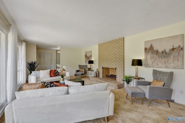 carpeted living room featuring brick wall, a brick fireplace, and a textured ceiling