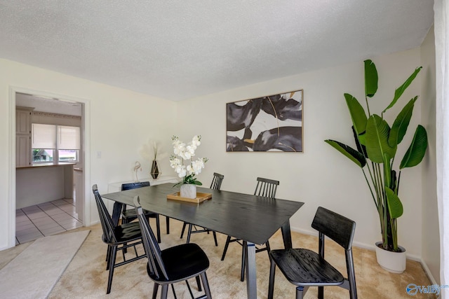 dining area featuring a textured ceiling and light tile patterned floors