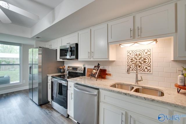 1908 Spanish Oaks Dr SE, Huntsville, AL 35803 - kitchen featuring stainless steel appliances, white cabinetry, backsplash, and wood finished floors
