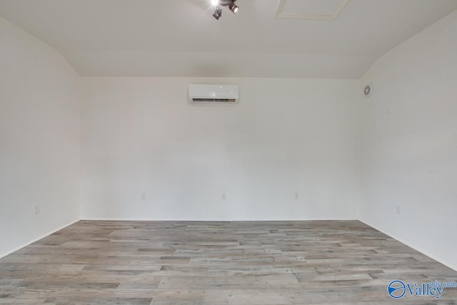 1908 Spanish Oaks Dr SE, Huntsville, AL 35803 - unfurnished room featuring a wall mounted air conditioner, wood finished floors, and lofted ceiling