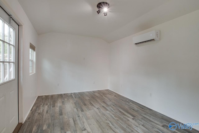 1908 Spanish Oaks Dr SE, Huntsville, AL 35803 - empty room featuring a wall mounted air conditioner, wood finished floors, and vaulted ceiling