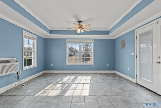 interior space with ceiling fan, light tile patterned floors, a tray ceiling, and ornamental molding