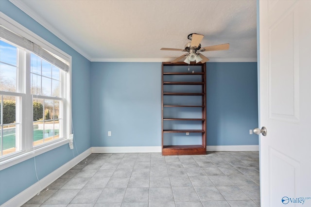 spare room with ceiling fan and crown molding