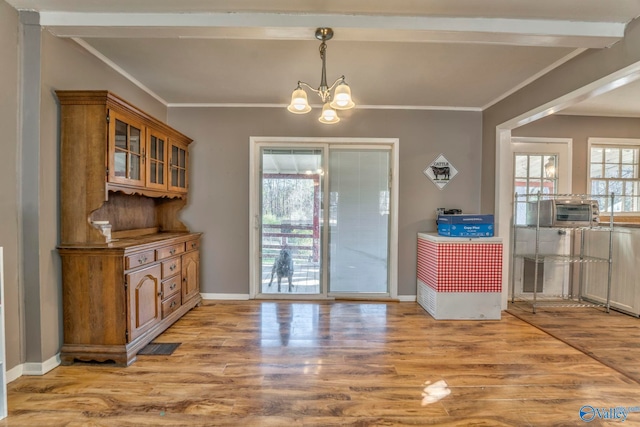 interior space featuring baseboards, light wood-type flooring, an inviting chandelier, and crown molding