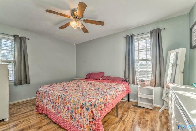 bedroom with light wood finished floors, ceiling fan, and baseboards