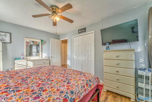 bedroom with light wood-style floors, a closet, and a ceiling fan