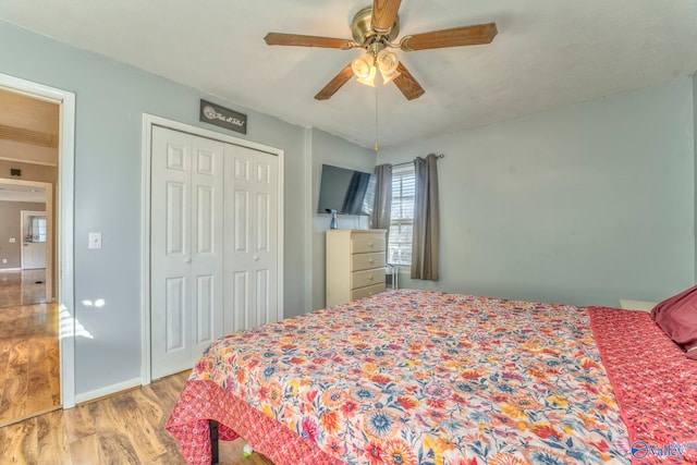 bedroom with light wood-style floors, a closet, baseboards, and a ceiling fan