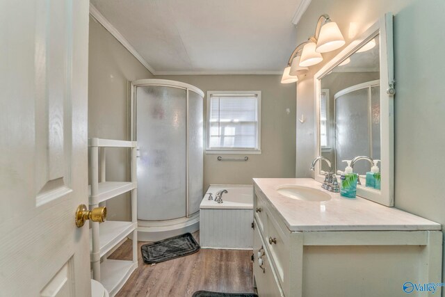 full bathroom featuring wood finished floors, vanity, a shower stall, a bath, and crown molding