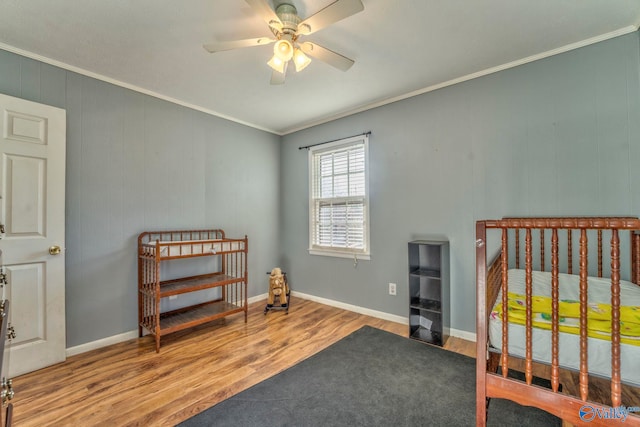 bedroom featuring light wood finished floors, baseboards, ornamental molding, and a ceiling fan