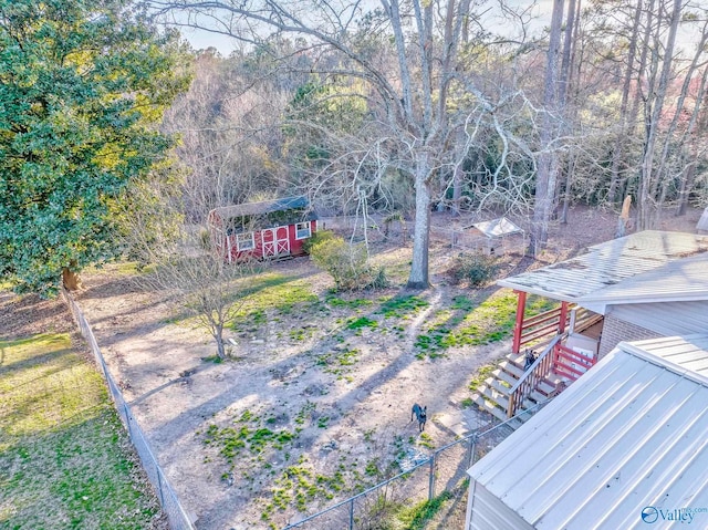 view of yard featuring a shed, fence, stairway, and an outbuilding