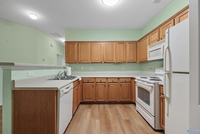 kitchen featuring kitchen peninsula, a textured ceiling, white appliances, sink, and light hardwood / wood-style floors