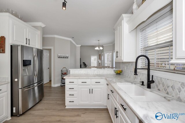 kitchen featuring white cabinets, a sink, a chandelier, stainless steel refrigerator with ice dispenser, and ornamental molding